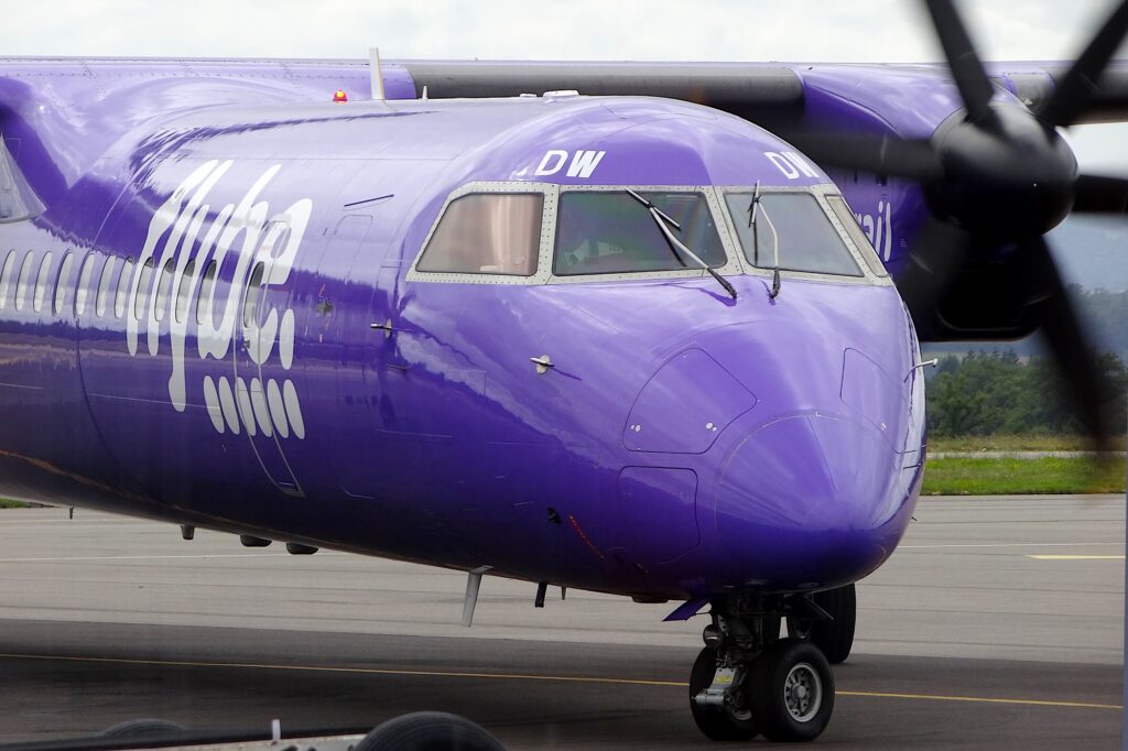 Самолет Flybe на взлетно-посадочной полосе с пилотом в окне